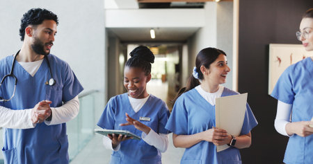 Walking, hospital and med students talking for consulting, medical advice and diagnosis. Healthcare, internship team and people with tablet, documents and meeting for results and treatment planの写真素材