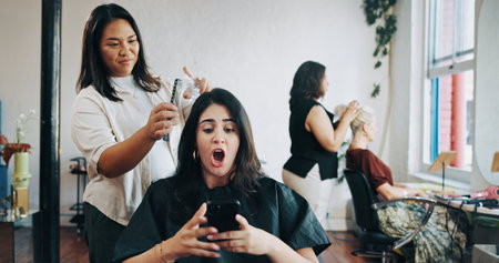 Woman, hairdresser and wow with phone, spray or talk for trim, texting or shock at salon. People, smartphone and customer with surprise notification on mobile app, social media or hairstyle at shopの写真素材