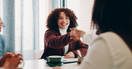 Woman, handshake and happy with team at startup, goals and congratulations at media company. Person, excited and shaking hands for success, celebration or smile for achievement at creative agencyの写真素材