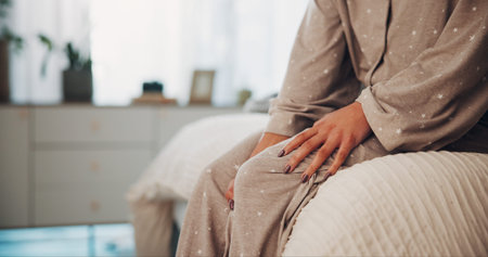 Home, hands and woman in bedroom, knee pain and sore leg with fibromyalgia, muscle stress or ache....