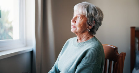 Thinking, window and senior woman in home for memory, reflection or nostalgia with depression. Sad,...