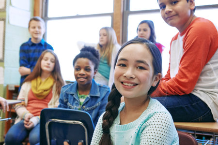 Portrait, education and student with girl in classroom for child development, future and learning. Knowledge, academy and lecture with group of kids in school for lesson, scholarship and growthの写真素材