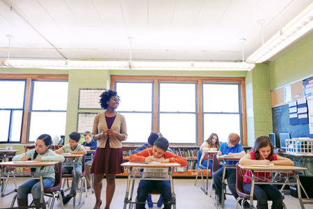 Teacher, education and lesson with woman in classroom for child development, growth and knowledge. Lecture, learning and teaching with person and kids in school for support, academy and studentsの写真素材