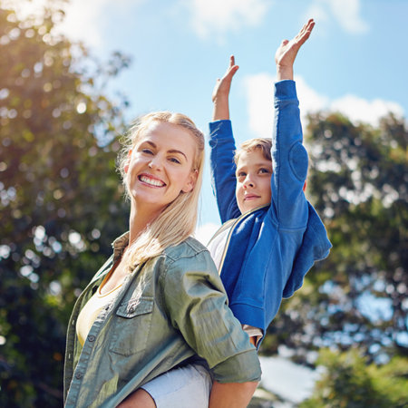 Mother, piggyback and child with smile outdoor for love, fun and bonding together on holiday. Portrait, woman or carry kid with family connection, playful games and freedom in nature on vacation tripの写真素材