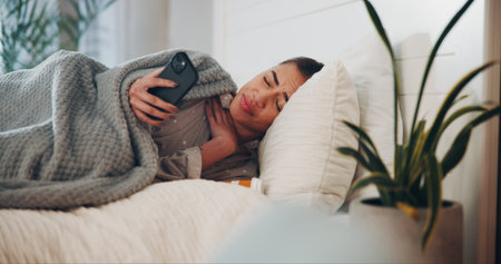 Woman, phone and sad in bed with pills, addiction or breakup with texting in home. Person with depression, smartphone and frustrated with mobile app, notification at apartmentの写真素材