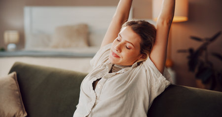 Woman, stretching and rest on living room sofa for weekend break and breathe in home. Relax, tired and person ready on couch in house with peace, exhausted and chilling in lounge for self careの写真素材