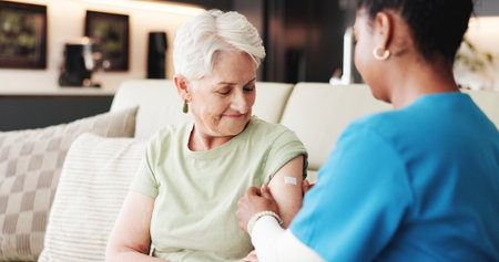 Doctor, old woman or help in home with bandage application for flu vaccine, healthcare or wellness. Nurse, elderly person or trust with immunity shot plaster, medical safety or protection from virus.の写真素材