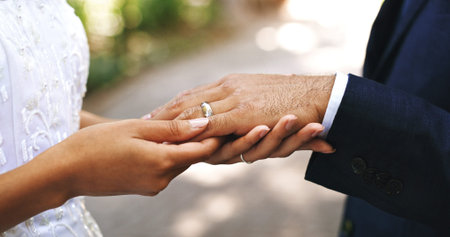 Wedding ring, love and hands of couple in park for marriage, bonding and commitment for celebration....