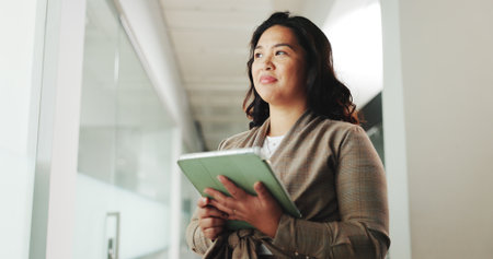 Thinking, woman and research with tablet, office and online for social media app. Reflection, person and schedule post on website, digital marketing and ad campaign and low angleの写真素材