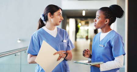 Tablet, discussion and women nurses in hospital with collaboration for medical consultation. Digital technology, teamwork and female healthcare employees with nursing career with records in clinic.の写真素材