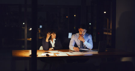 Stress, documents and business people in office at night with planning finance report with budget. Mistake, deadline and team of financial advisors with paperwork for investment proposal in workplaceの写真素材