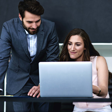 Business, people and smile in office with laptop for teamwork, collaboration and planning as accountant. Employee, partnership and satisfied with financial reviews, records and company revenueの写真素材