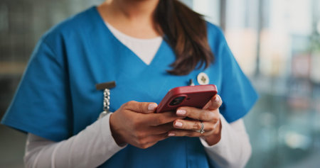 Phone, hands and woman nurse in hospital with typing for texting, communication or email for telehealth. Service, technology and healthcare worker with cellphone for contact or medical support.の写真素材