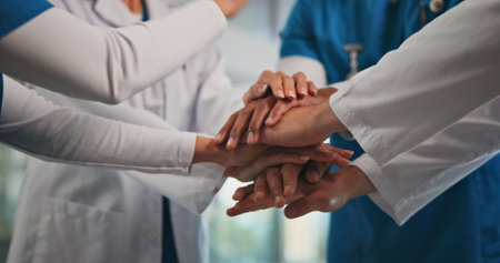 Closeup, nurses and doctors with handstack in hospital for celebration, surgery success and victory. People, healthcare workers and huddle for medical milestone, staff motivation and team achievementの写真素材