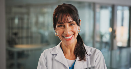 Happy, woman and doctor with portrait in hospital for career pride, about us and medical service. Smile, female person and ambition for healthcare assistance, patient care and confidence for wellnessの写真素材