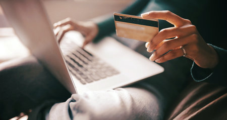 Hands, credit card and laptop on sofa for e commerce, easy payment or transaction in home. Person, computer and digital banking with fintech, bills or financial freedom for online shopping at houseの写真素材