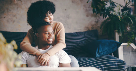 Thinking, couple and hug in lounge, chill and bonding on break with smile, trust and romance in home. Happy, man and embrace with woman in living room, affection and reflection for future or marriageの写真素材