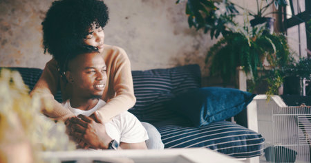 Thinking, couple and hug in lounge, break and bonding on couch with smile, trust and romance in home. Happy, man and embrace with woman in living room, reflection and affection for partner in houseの写真素材