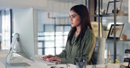 Online, research and woman with computer, office and email marketing on web, serious and copywriting. Typing, project and person with info for article, copywriter and creative with technology or appの写真素材