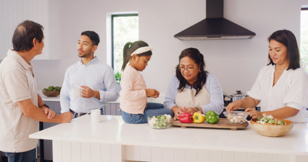 Grandparents, parents and kid in kitchen for cooking, learning skills and help for lunch. Family home, senior generations and mom, dad and girl for bonding, talking and prepare food for supperの写真素材