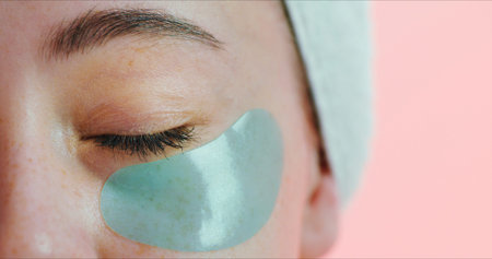 Beauty, skincare and eye with patch in studio, reduce dark circles and hydration treatment for...