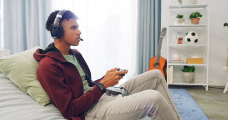Couch, esport and teenager playing video game with controller in living room for online challenge in...