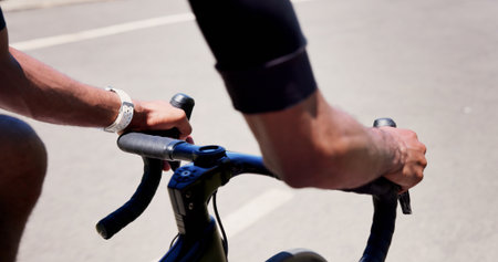 Cycling, hands and athlete on bicycle, outdoor and practice competition on road, active and journey. City, cyclist and person on bike for sport tournament, travel and eco friendly transport on streetの写真素材