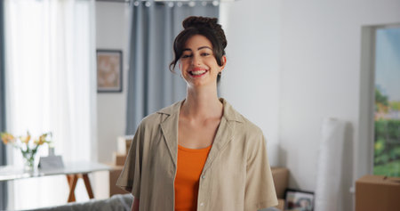 Property, portrait and woman in living room with pride, fresh start and investment in dream house. Success, real estate and girl in home with confidence, relocation and achievement for new homeownerの写真素材