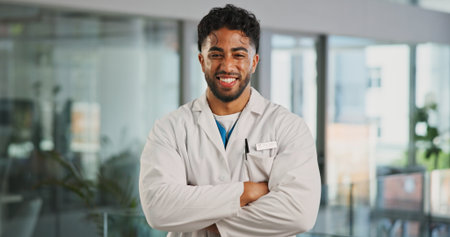 Portrait, man and doctor with arms crossed in hospital for career pride, about us and medical service. Happy, male person and ambition for healthcare advice, patient care and confidence for wellnessの写真素材