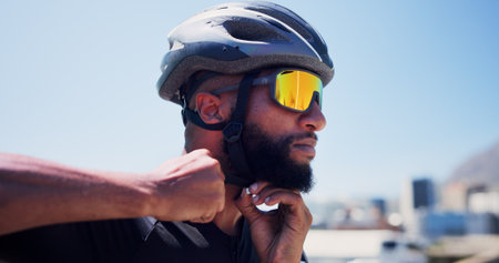Sports, helmet and man with strap in city ready for exercise, training and active hobby outdoor. Fitness, athlete and person with safety gear, sunglasses and protection for workout, cycling and rideの写真素材