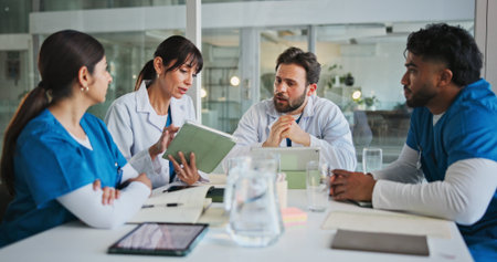 Nurses, doctors and tablet with discussion in meeting for surgery schedule, clinic budget or update. Medical team, people and feedback with tech in hospital for health results and treatment optionsの写真素材