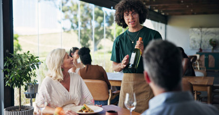 Wine bottle, hospitality and couple in restaurant, waiter and conversation with customer service....