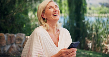 Funny, smartphone and woman with internet, outdoor and laughing with social media. Mature person,...