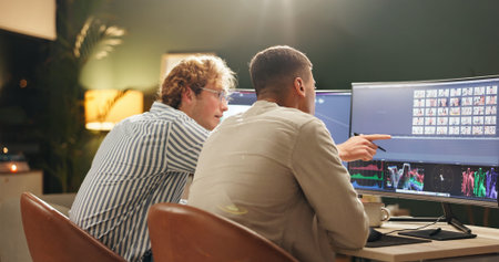 Night, creative and people in office with computer, image review and selection for digital marketing. Late, team and point with desktop for photography chat, brainstorming or insight for advertising.の写真素材