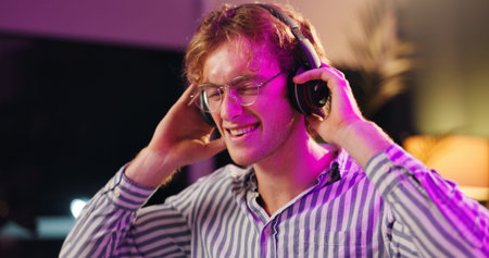 Happy, man and music with headphones, smile and listening to audio track for broadcast at night....