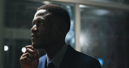 Night, thinking and black man in office with project, business plan and brainstorming at digital...