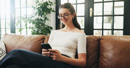 Girl, phone and smile on sofa with typing, communication or texting in home. Student, tech and...