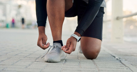 Person, hands and tying with shoes for fitness, workout preparation or outdoor exercise. Active,...