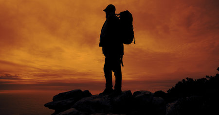 Sunset, hiking and silhouette of man on mountain for adventure, reflection and view of ocean....