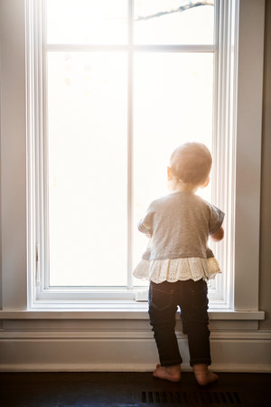Back, baby and window with girl at house for curiosity, discovery and observing surroundings. Child,...