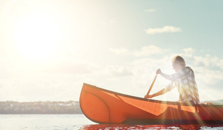 Kayaking, lake and woman on boat in nature on holiday, adventure or weekend trip with exploring. Travel, lens flare and female person with canoeing challenge on river for summer vacation outdoor.の写真素材
