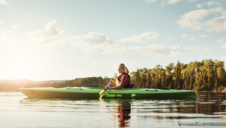 Kayak, woman on river with boat, recreation hobby and summer exploration on vacation. Flare, rowing or female person in nature with canoe, lake getaway and water sports.の写真素材