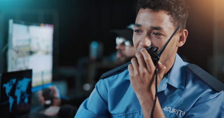 Man, security or talking with radio for safety measure, precaution or protection in control room. Male person, officer or night guard with signal response or cctv footage for crime alert or detectionの写真素材