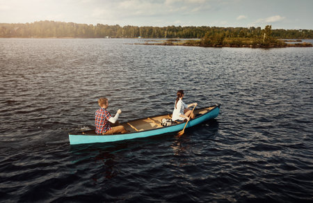 Rowing, above or couple on river with boat, weekend break and healthy relationship on outdoor trip....