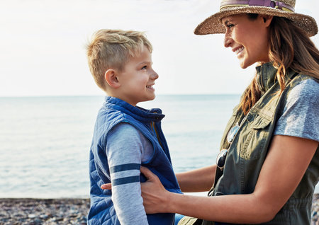 Love, smile and mother with son at beach for bonding, summer vacation and connection. Support,...