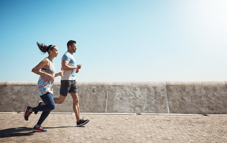 Promenade, running and couple with sunshine, fitness for wellness and earphones. Space, healthy man...