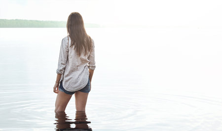 Woman, back and view with thinking in lake with break, sightseeing and space on summer vacation....