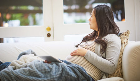 Pregnant woman, thinking and relax with tablet on sofa for motherhood tips or health in home....