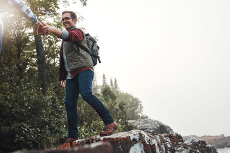 Happy couple, hiking and holding hands on mountain rock for outdoor adventure, travel or journey....
