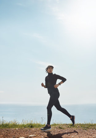 Fitness, woman and running by ocean for health, cardio wellness and endurance training. Athlete,...